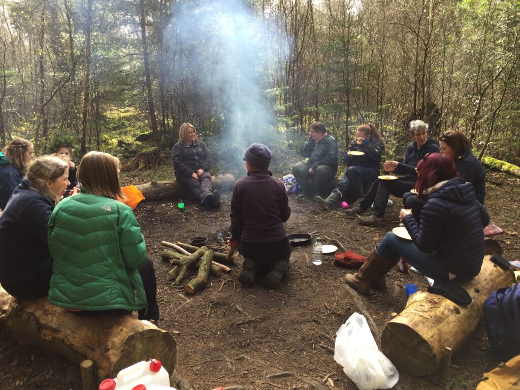 Women and girls round a camp fire