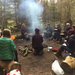 Women and girls round a camp fire